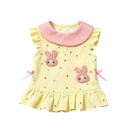 A yellow sleeveless dog dress with a pink Peter Pan collar, decorated with two pink bunny patches, small heart prints, and pink ribbon bows on the sides.