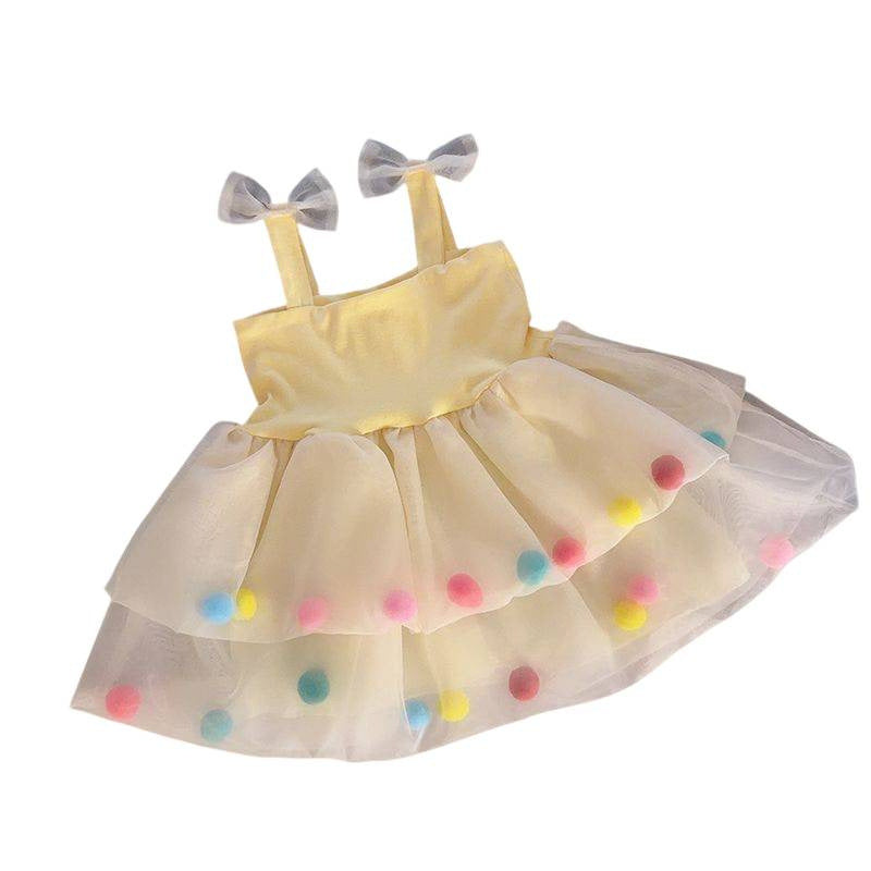 A dog yellow tulle tutu dress with a solid yellow bodice, matching yellow straps decorated with small gray bows, and a tiered skirt adorned with colorful pastel pom-poms.